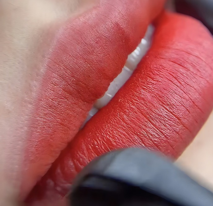 Close-up of lip permanent makeup in a soft coral red